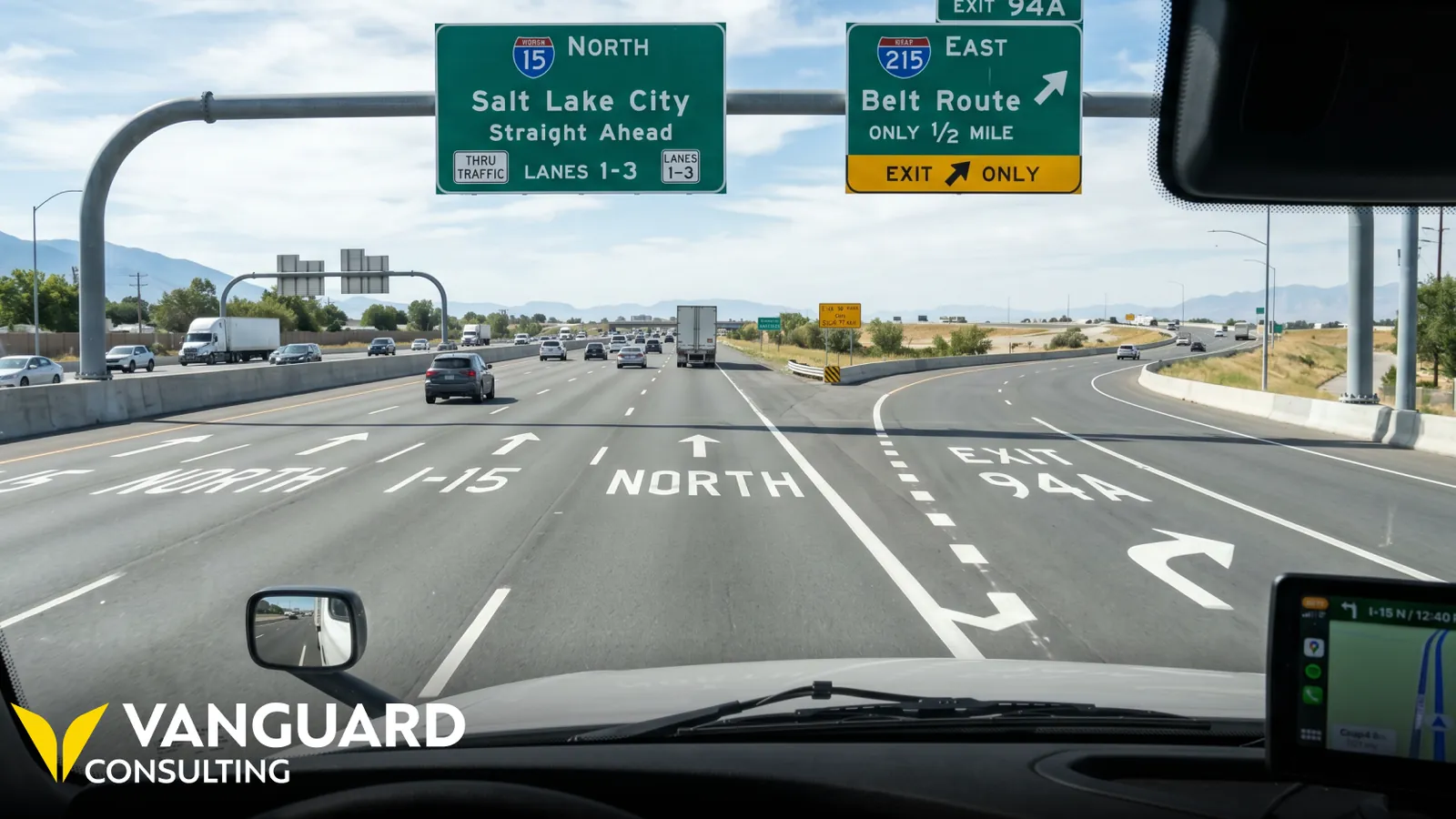 Driver's view of a highway where through lanes continue ahead and an exit lane splits away to the right.